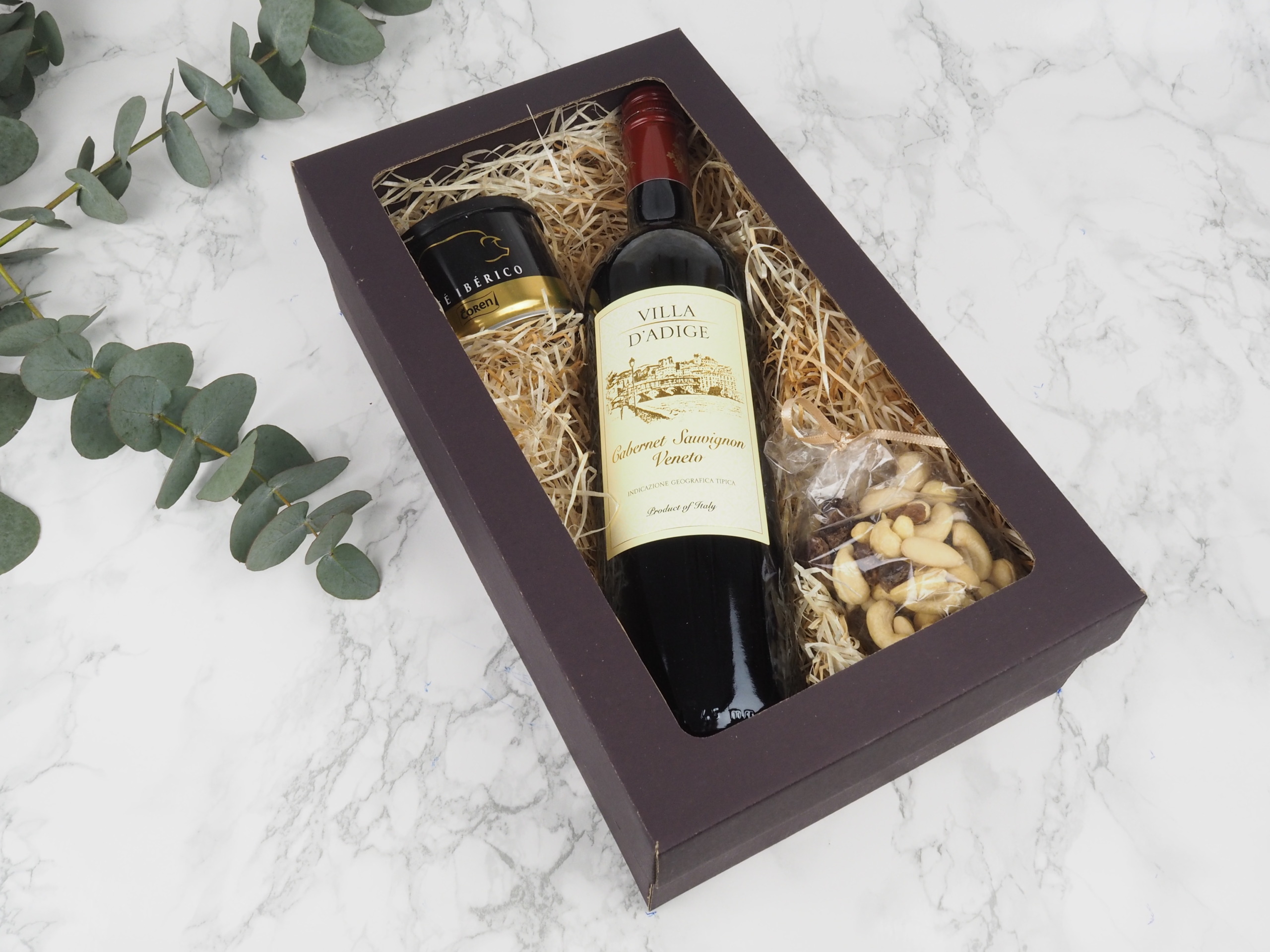 Dárkový balíček Brown Veneto v sobě obsahuje italské červené víno Merlot Veneto, španělskou vepřovou paštiku Ibérico a mix oříšků.