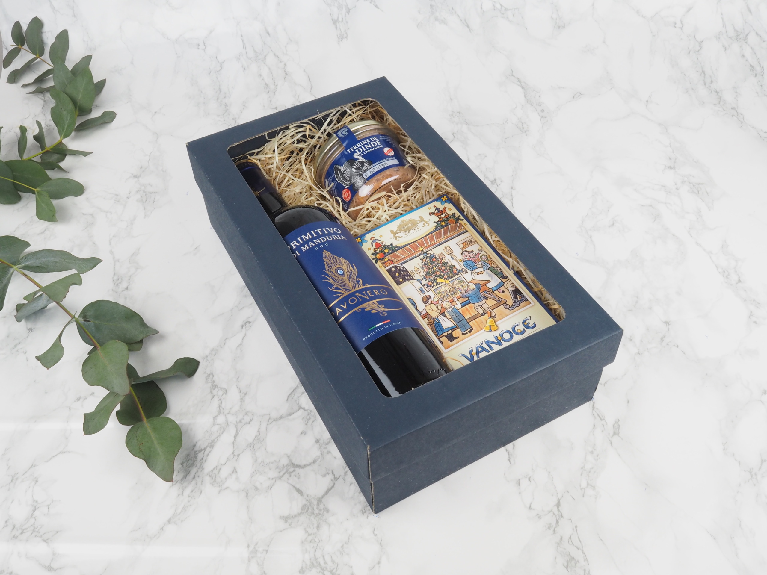 Dárkový balíček Modrý Lada v sobě obsahuje červené italské víno Primitivo, francouzskou terinu s Armagnacem a mléčnou čokoládu s ilustrací Josefa Lady.