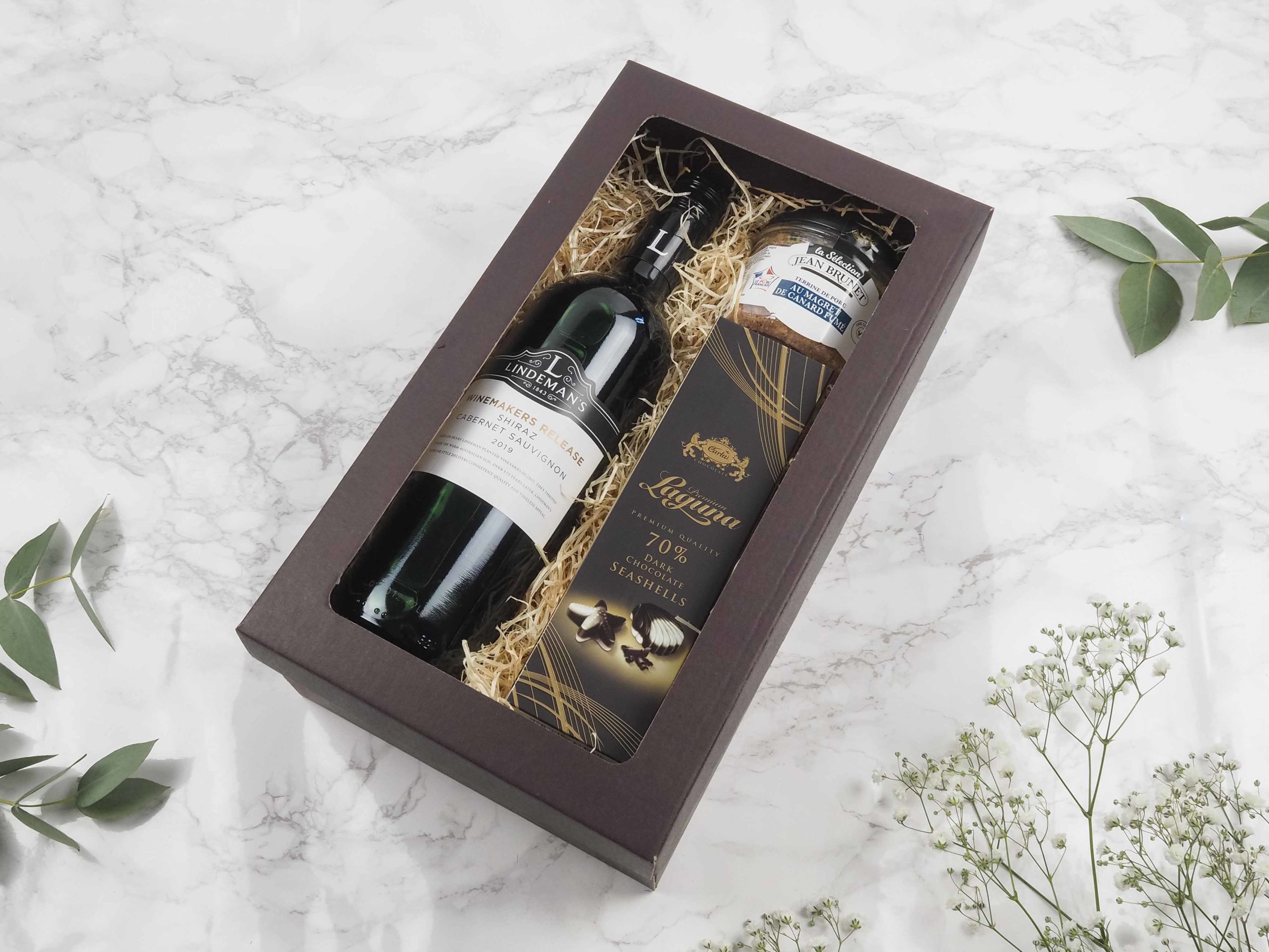 Dárková krabička v sobě ukrývá kvalitní australské červené víno, vepřová terina s uzenými kachními prsy a belgické pralinky. Všechny pochutiny jsou baleny v elegantní a ekologické papírové krabičce. Obdarujte s chutí malým degustačním zážitkem.
