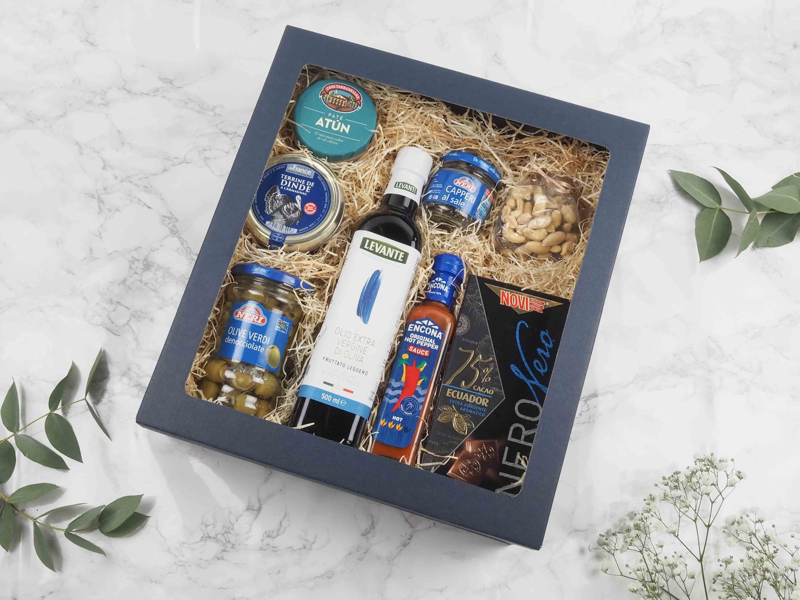 Dárková krabička v sobě ukrývá kvalitní italský olivový olej, paté z tuňáka, krůtí terina s Armagnacem, zelené olivy bez pecek, kapari naložené v hrubé soli, chilli omáčka, mix oblíbených oříšků a 75% hořká čokoláda. Všechny pochutiny jsou baleny v elegantní a ekologické papírové krabičce. Obdarujte s chutí malým degustačním zážitkem.
