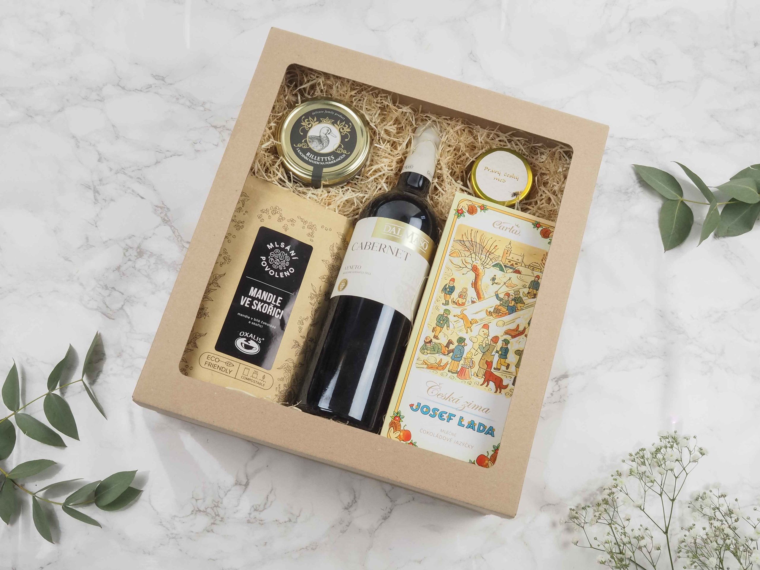 Dárková krabička v sobě ukrývá kvalitní červené víno Cabernet Veneto, mandle ve skořici, rilettes s masem z divočáka, pravý český med z Kokořínska, mléčná čokoláda s ilustrací Josefa Lady. Všechny pochutiny jsou baleny v elegantní a ekologické papírové krabičce. Obdarujte s chutí malým degustačním zážitkem.