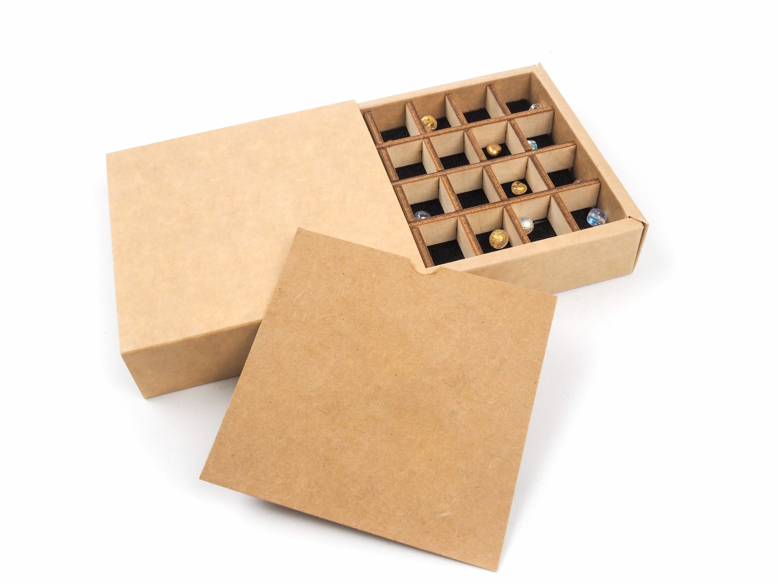 Dárková krabička byla vyrobena k sadě korálků. K jejich ochraně byla do krabičky vložena vždy dřevěná mřížková "proložka", a aby korálky hezky při otevření vynikly, byl pod ně vložek černý papír. Na korálky byl následně vložen letáček s popisem v barvě krabičky.