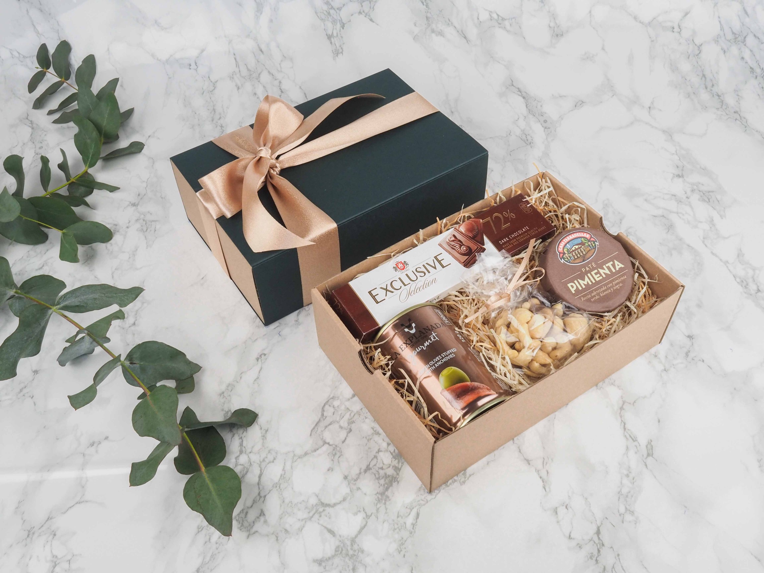 Dárkový balíček Exclusice Gourmet je speciální svou elegantní vysouvací krabičkou, kterou zdobí atlasová stuha. Dárková krabice v sobě obsahuje mléčnou čokoládu, zelené olivy s ančovičkami, mix oříšků a španělskou paštiku s pepřem.