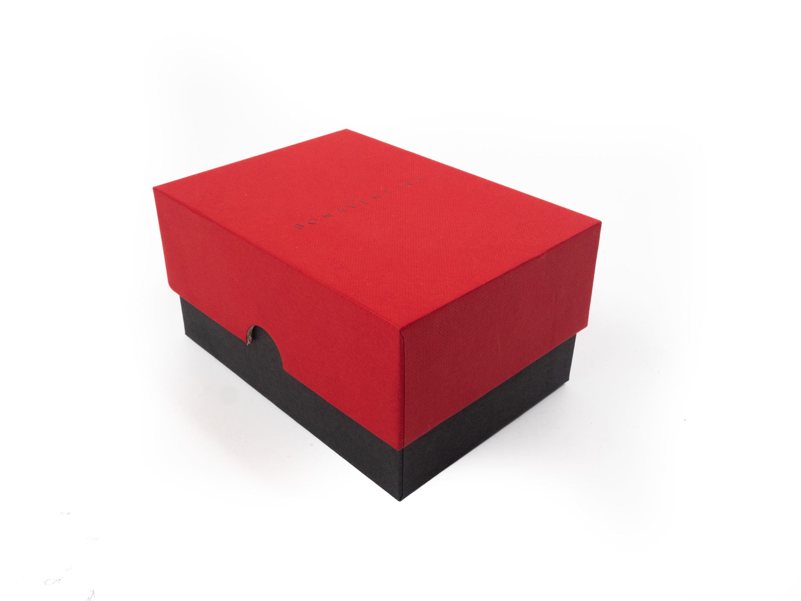 Dárková krabice v provedení víko/dno byla vyrobena na zakázku ve dvou barevném provedení. Víčko je v červené barvě se strukturou a dno v černém potahu bez struktury. Na víčku černá ražba loga.